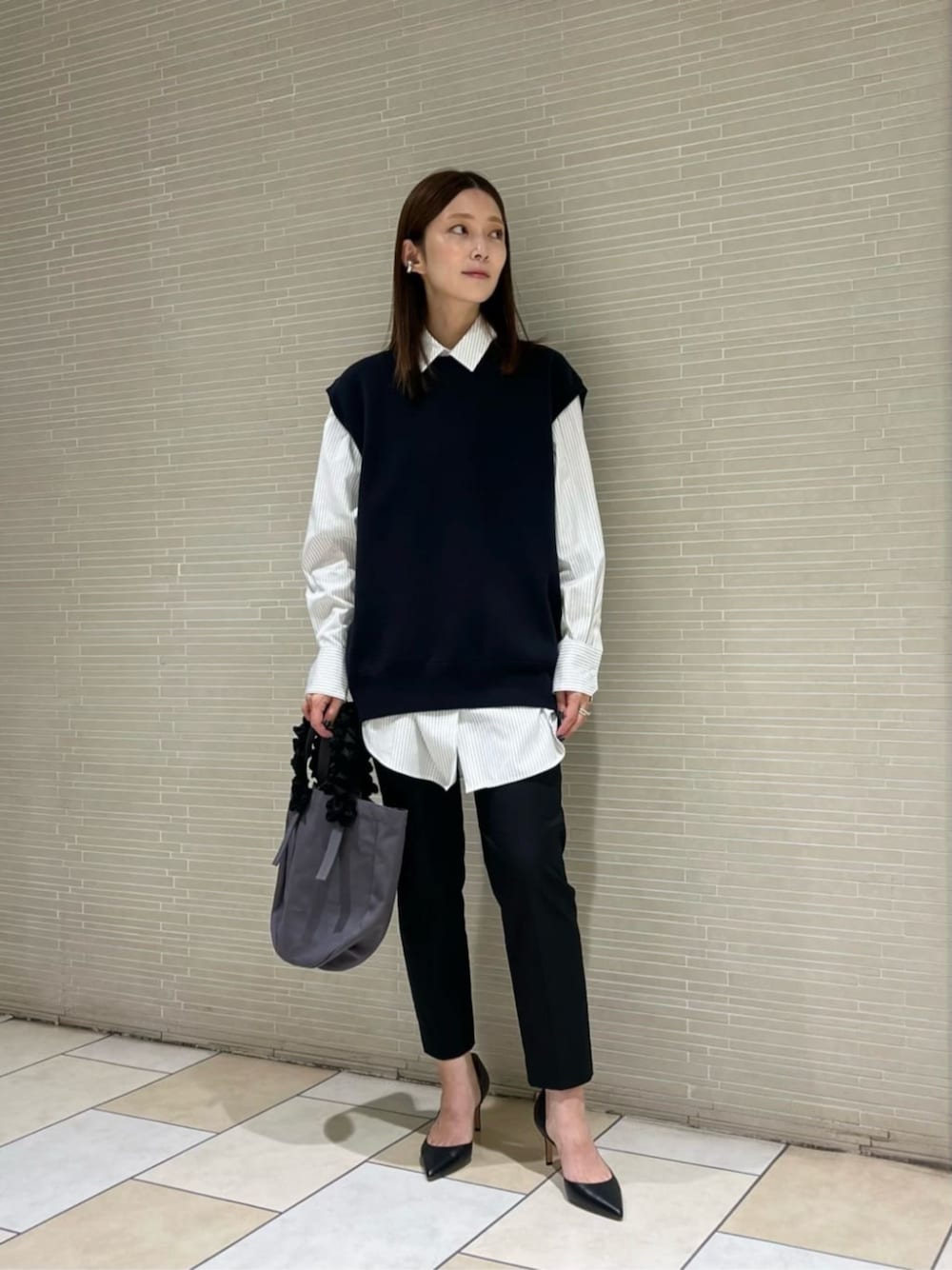 ブラック系のスラックス、その他のシャツ/ブラウス、ブルー系のニット/セーターを着用したレディースの秋コーディネートの1枚目の写真