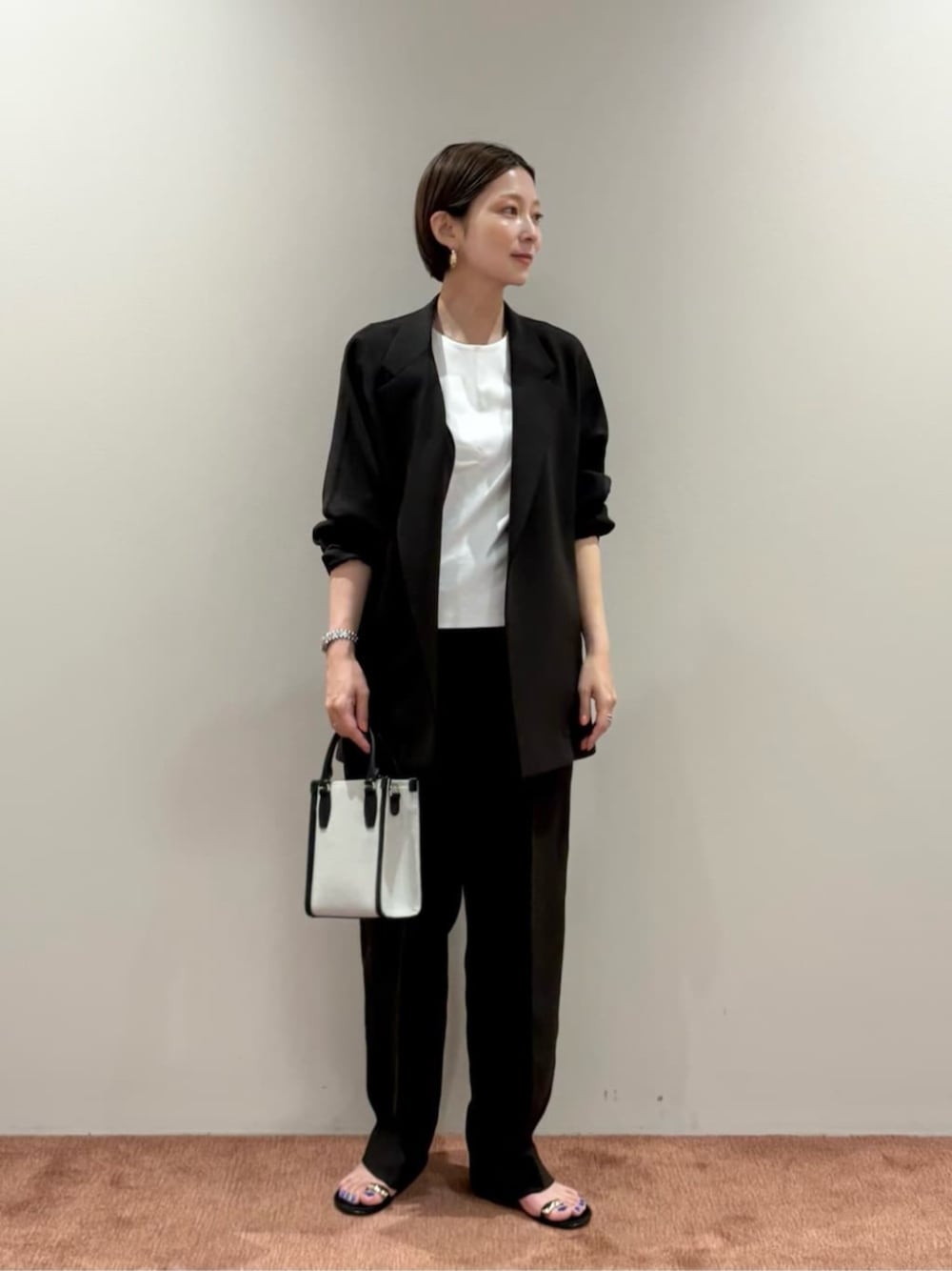 ブラウン系のその他パンツ、ホワイト系のTシャツ/カットソー、ブラック系のトートバッグを着用したレディースの夏コーディネートの1枚目の写真