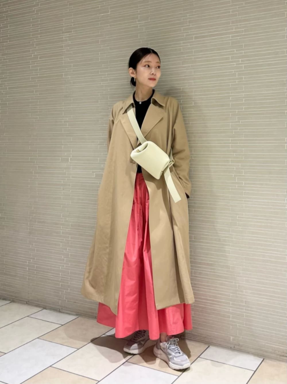 ブラック系のカーディガン/ボレロ、ベージュ系のトレンチコート、ピンク系のスカートを着用したレディースの春コーディネートの1枚目の写真