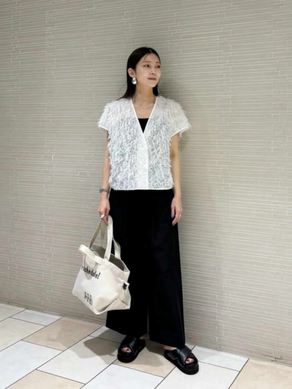 ブラック系のサンダル、ブラック系のその他パンツ、ホワイト系のベストを着用したレディースの夏コーディネートの1枚目の写真