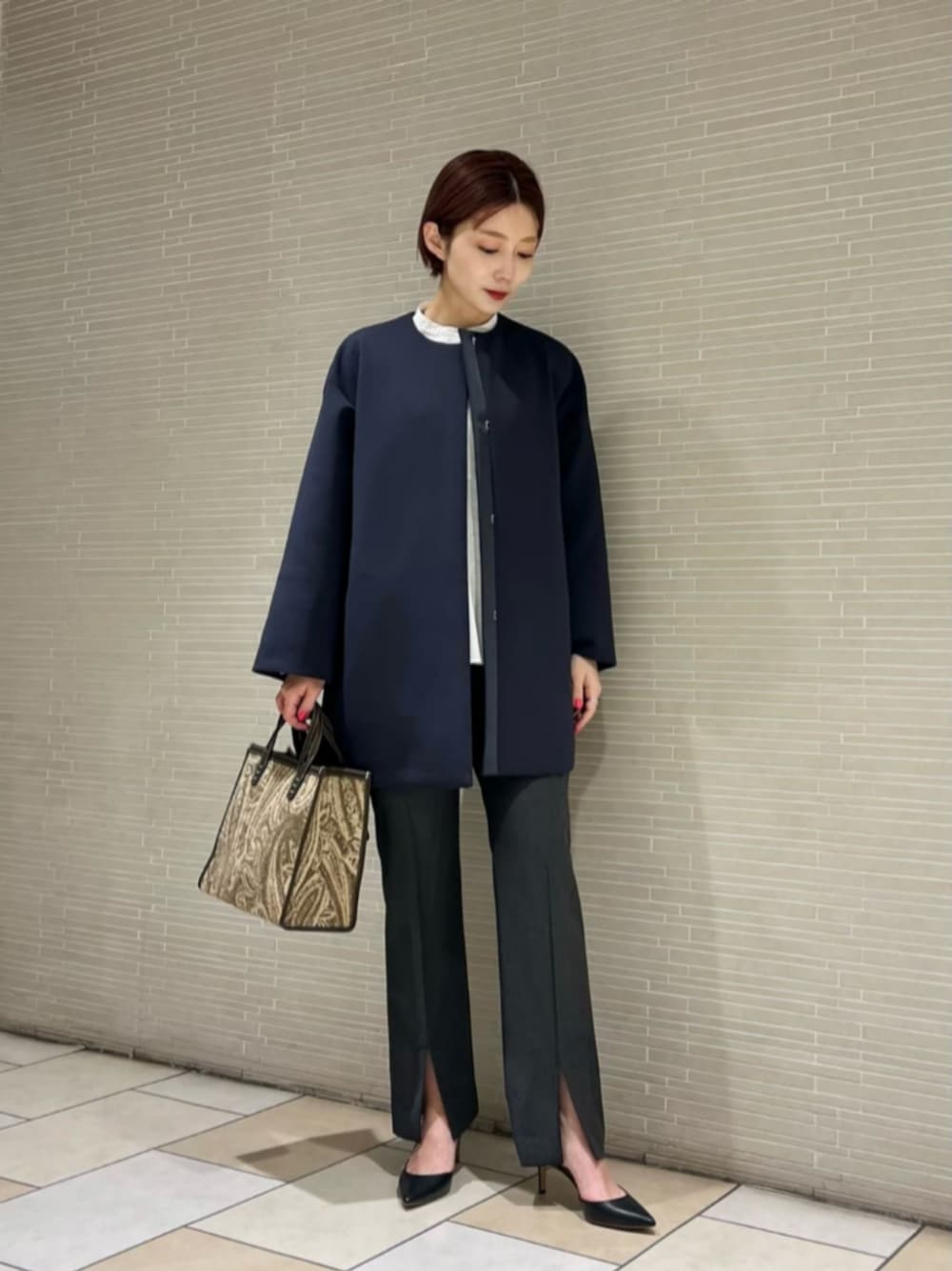 ブラック系のパンプス、グレー系のその他パンツ、ホワイト系のシャツ/ブラウスを着用したレディースの冬コーディネートの1枚目の写真