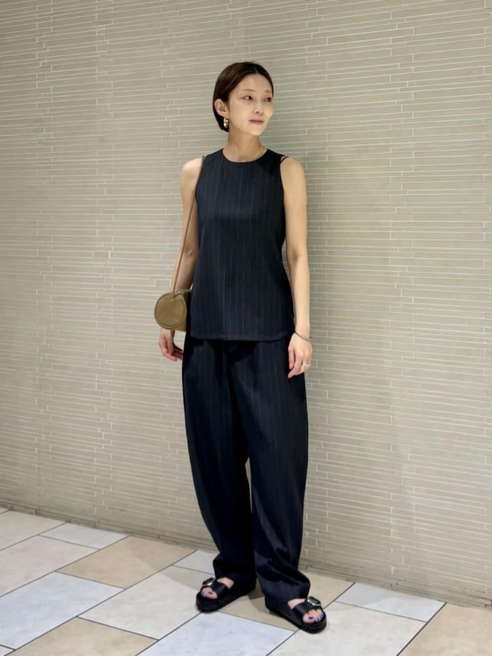 ブラック系のサンダル、グレー系のシャツ/ブラウス、グレー系のその他パンツを着用したレディースの夏コーディネートの1枚目の写真