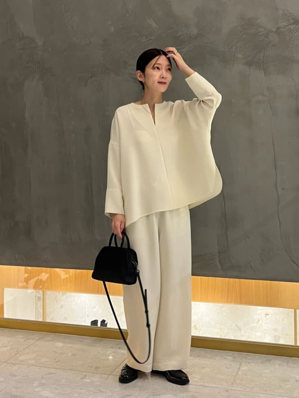 ブラック系のローファー、ホワイト系のその他パンツ、ブラック系のボストンバッグを着用したレディースの冬コーディネートの1枚目の写真