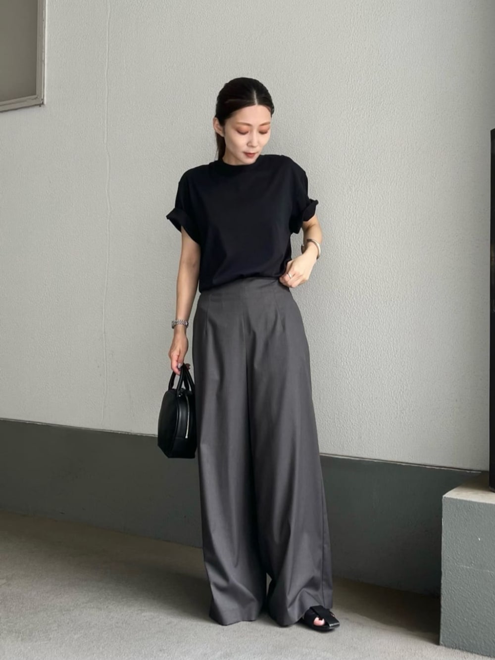 ブラック系のショルダーバッグ、ブラック系のTシャツ/カットソー、グレー系のその他パンツを着用したレディースの夏コーディネートの1枚目の写真