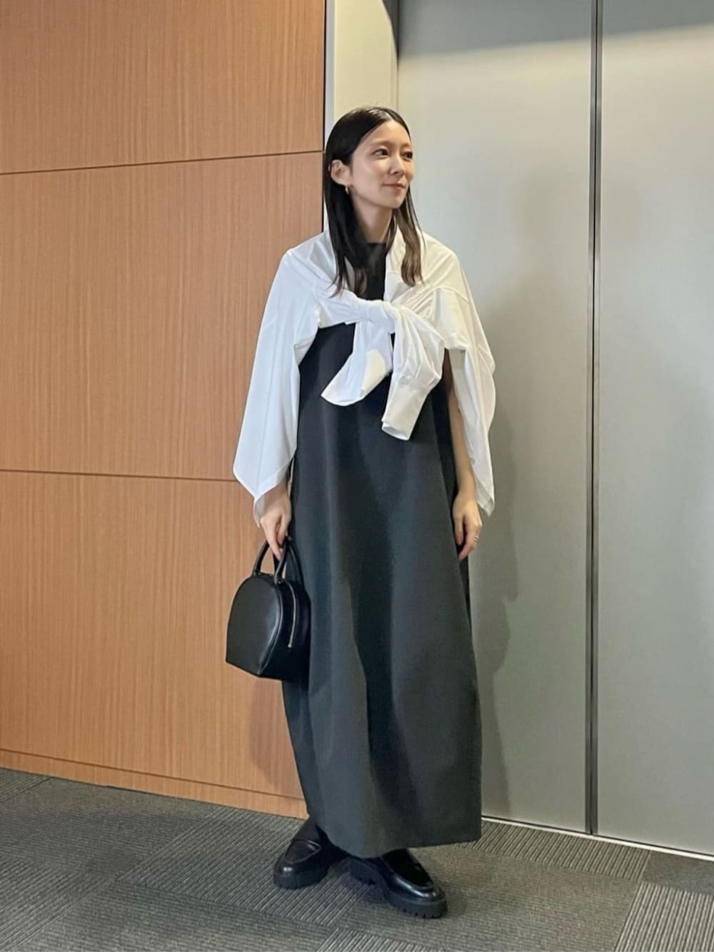 ブラック系のショルダーバッグ、グレー系のワンピース、ホワイト系のシャツ/ブラウスを着用したレディースの冬コーディネートの1枚目の写真