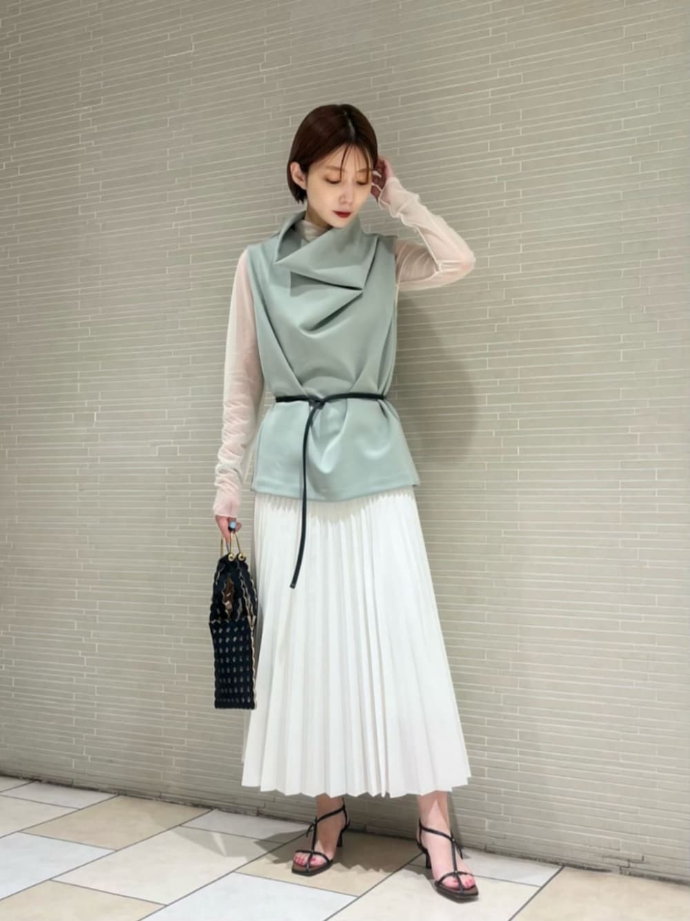 ホワイト系のTシャツ/カットソー、ホワイト系のスカート、ブラック系のサンダルを着用したレディースの春コーディネートの1枚目の写真