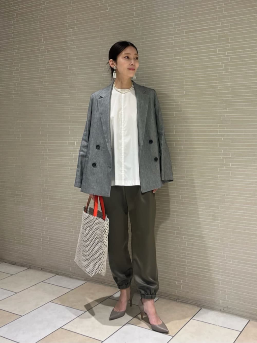 ベージュ系のパンプス、レッド系のトートバッグ、その他のテーラードジャケットを着用したレディースの春コーディネートの1枚目の写真