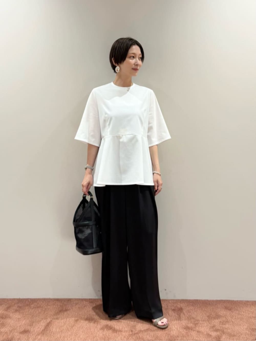 ブラック系のその他パンツ、ブラック系のハンドバッグ、ホワイト系のTシャツ/カットソーを着用したレディースの夏コーディネートの1枚目の写真