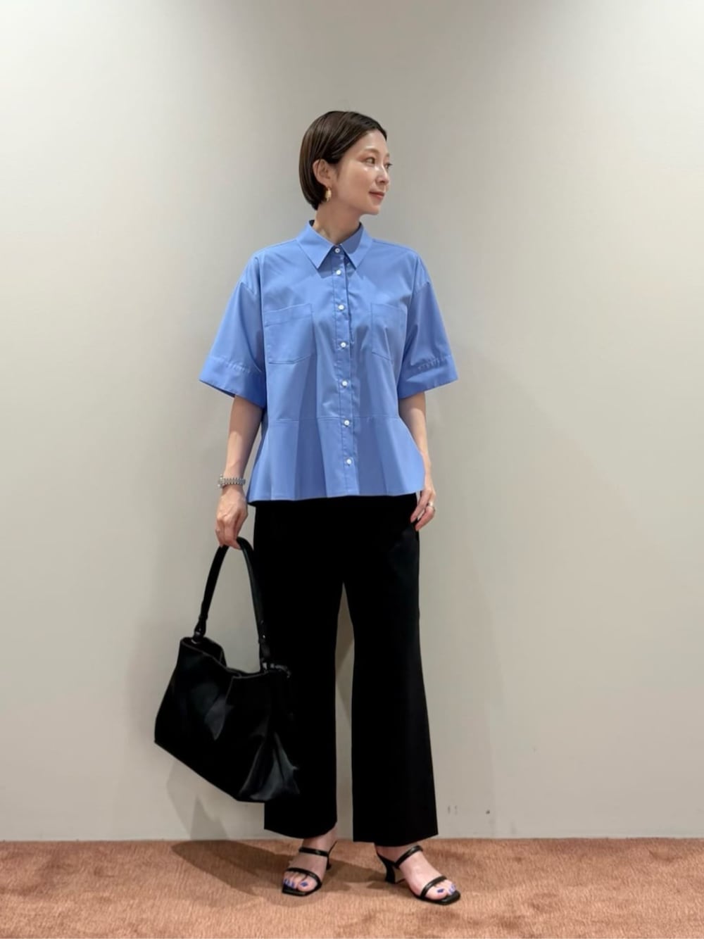 ブラック系のスラックス、ブルー系のシャツ/ブラウス、ブラック系のトートバッグを着用したレディースの夏コーディネートの1枚目の写真