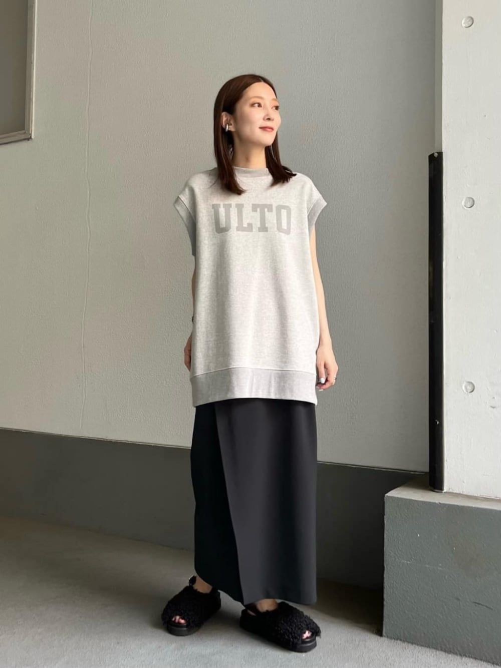 ブラック系のサンダル、ブラック系のスカートを着用したレディースの秋コーディネートの1枚目の写真