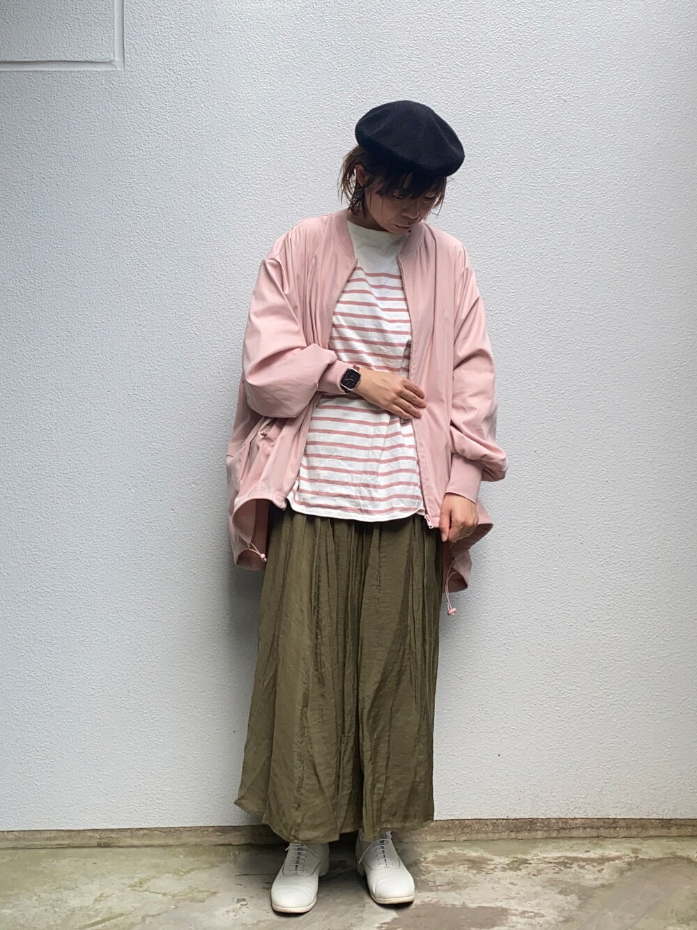 ピンク系のブルゾン、ホワイト系のTシャツ/カットソー、グリーン系のスカートを着用したレディースの春コーディネートの1枚目の写真