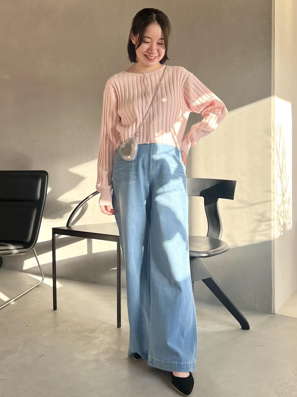 ピンク系のカーディガン/ボレロ、ブルー系のデニムパンツ、ブラック系のパンプスを着用したレディースの冬コーディネートの1枚目の写真