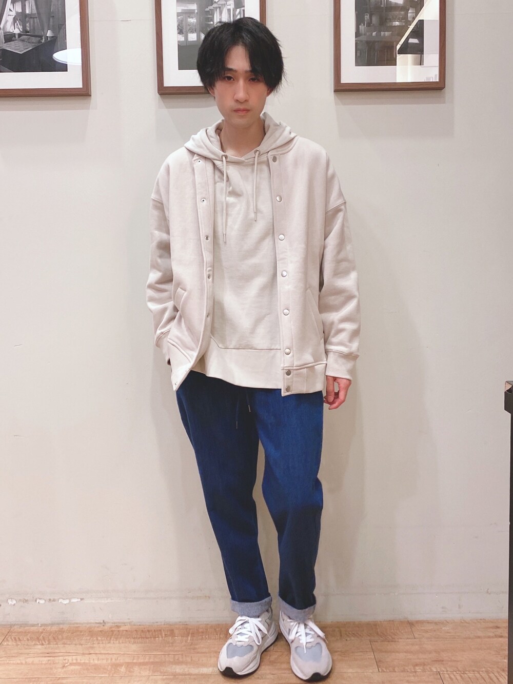 ホワイト系のブルゾン、ホワイト系のパーカー、ブルー系のデニムパンツを着用したメンズの秋コーディネートの1枚目の写真