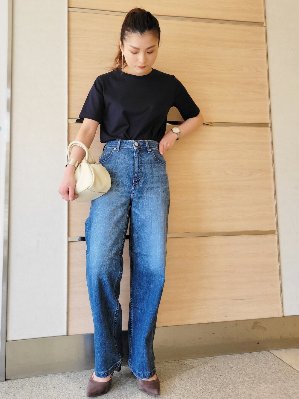 ブルー系のTシャツ/カットソー、ブルー系のデニムパンツ、ホワイト系のハンドバッグを着用したレディースの春コーディネートの1枚目の写真