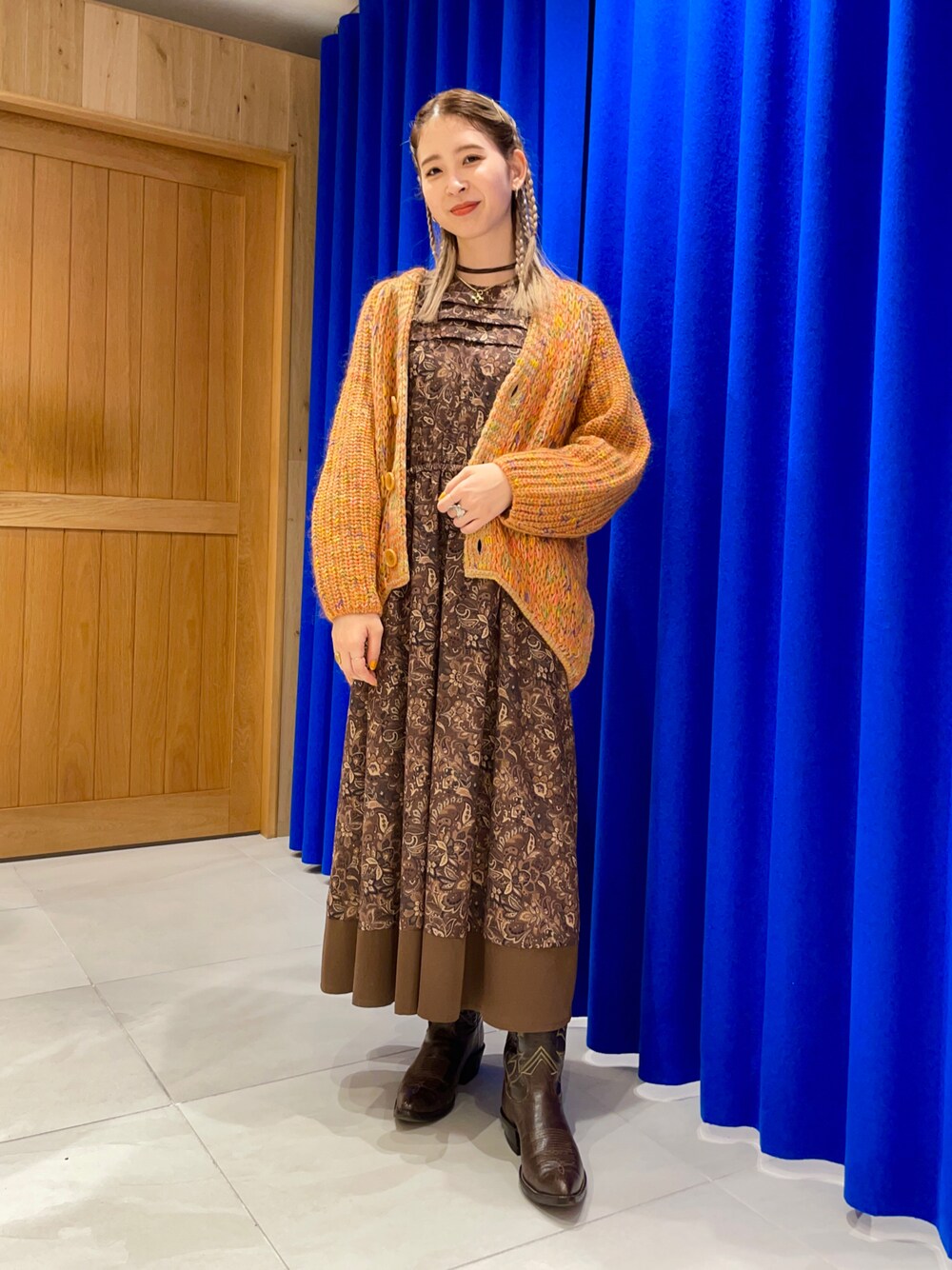 ブラウン系のワンピース、オレンジ系のカーディガン/ボレロを着用したレディースの秋コーディネートの1枚目の写真