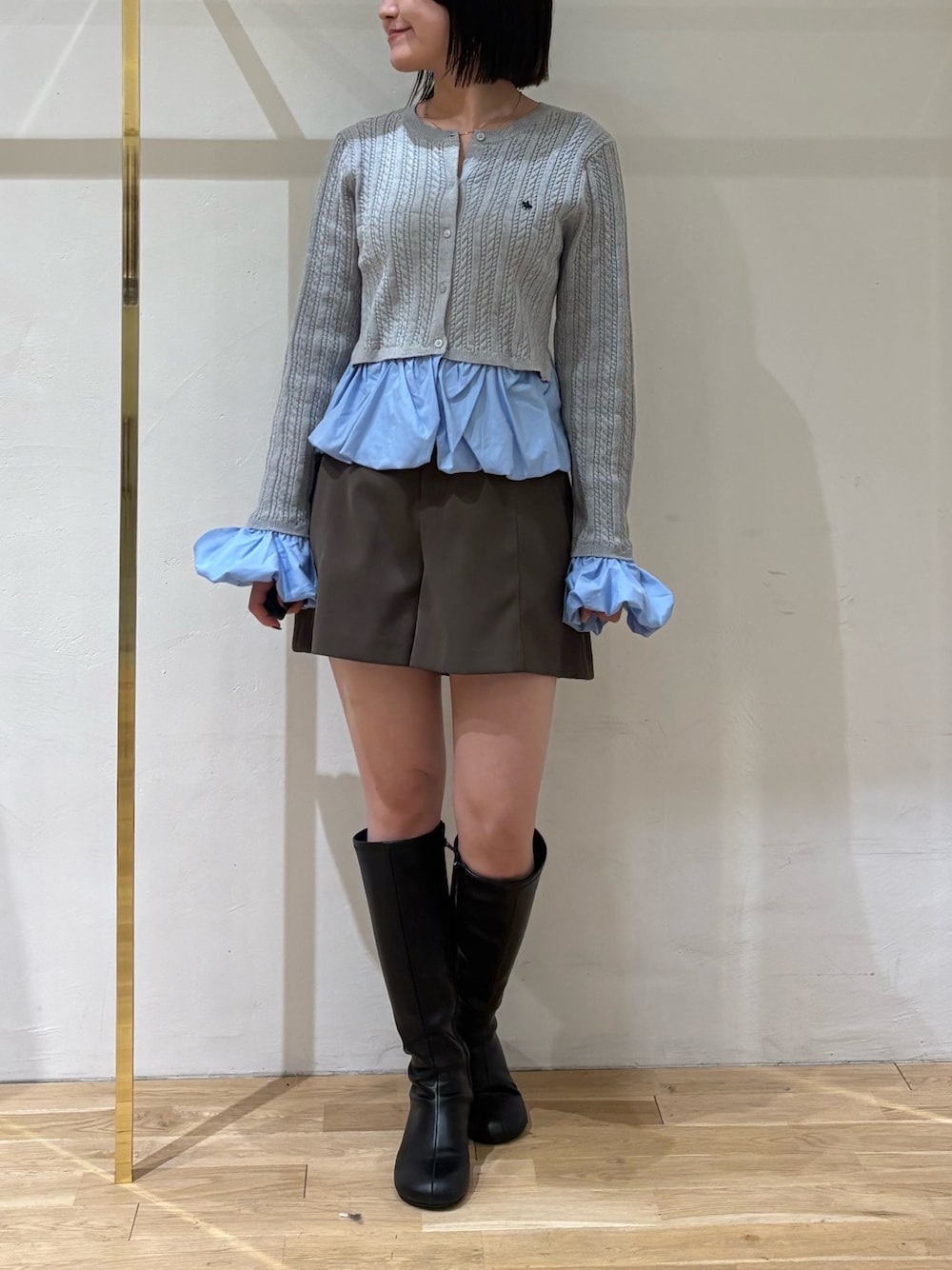 グレー系のニット/セーター、ブラウン系のその他パンツ、ブラック系のブーツを着用したレディースの秋コーディネートの1枚目の写真