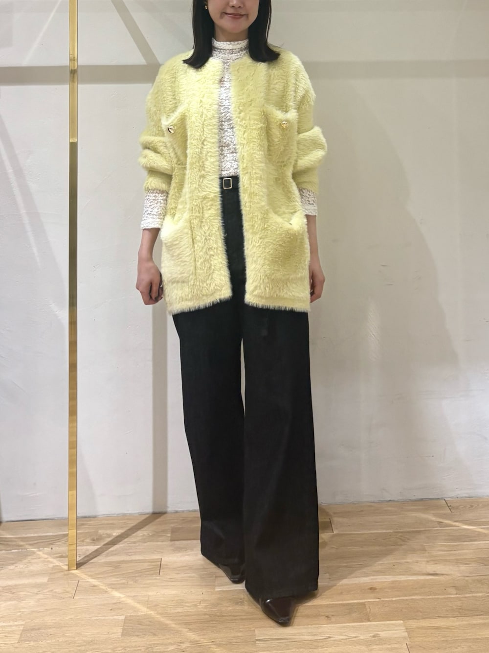 ブラック系のデニムパンツ、ホワイト系のTシャツ/カットソー、イエロー系のカーディガン/ボレロを着用したレディースの秋コーディネートの1枚目の写真