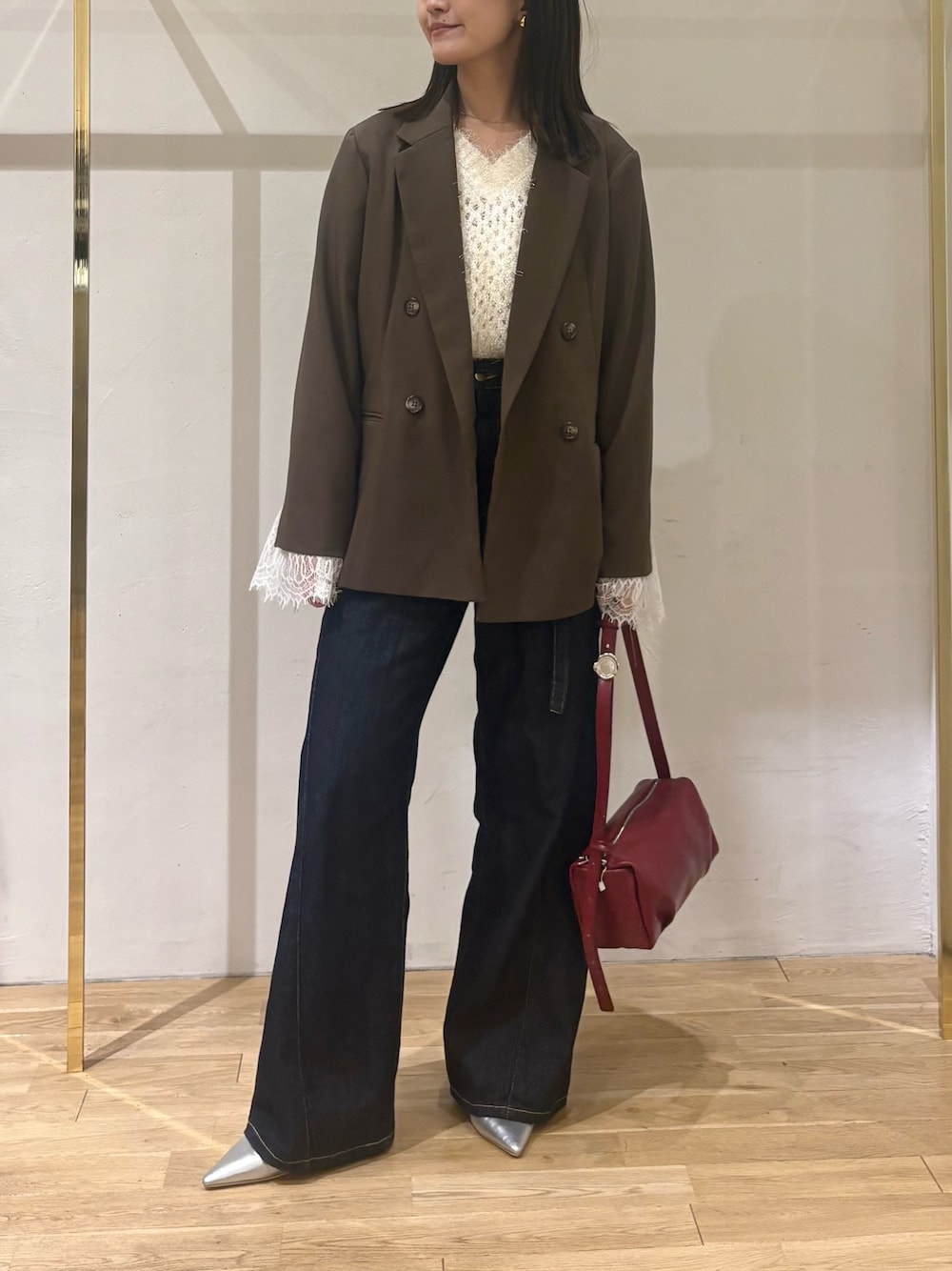 ホワイト系のニット/セーター、ブラウン系のテーラードジャケット、ブルー系のデニムパンツを着用したレディースの秋コーディネートの1枚目の写真