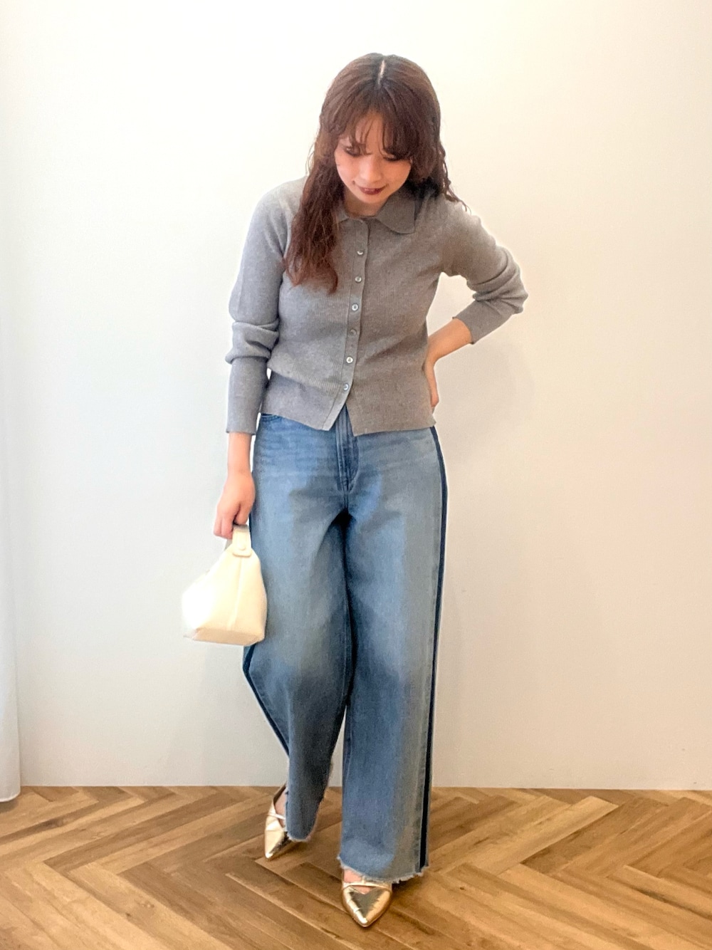 ブルー系のデニムパンツ、グレー系のニット/セーターを着用したレディースの秋コーディネートの1枚目の写真