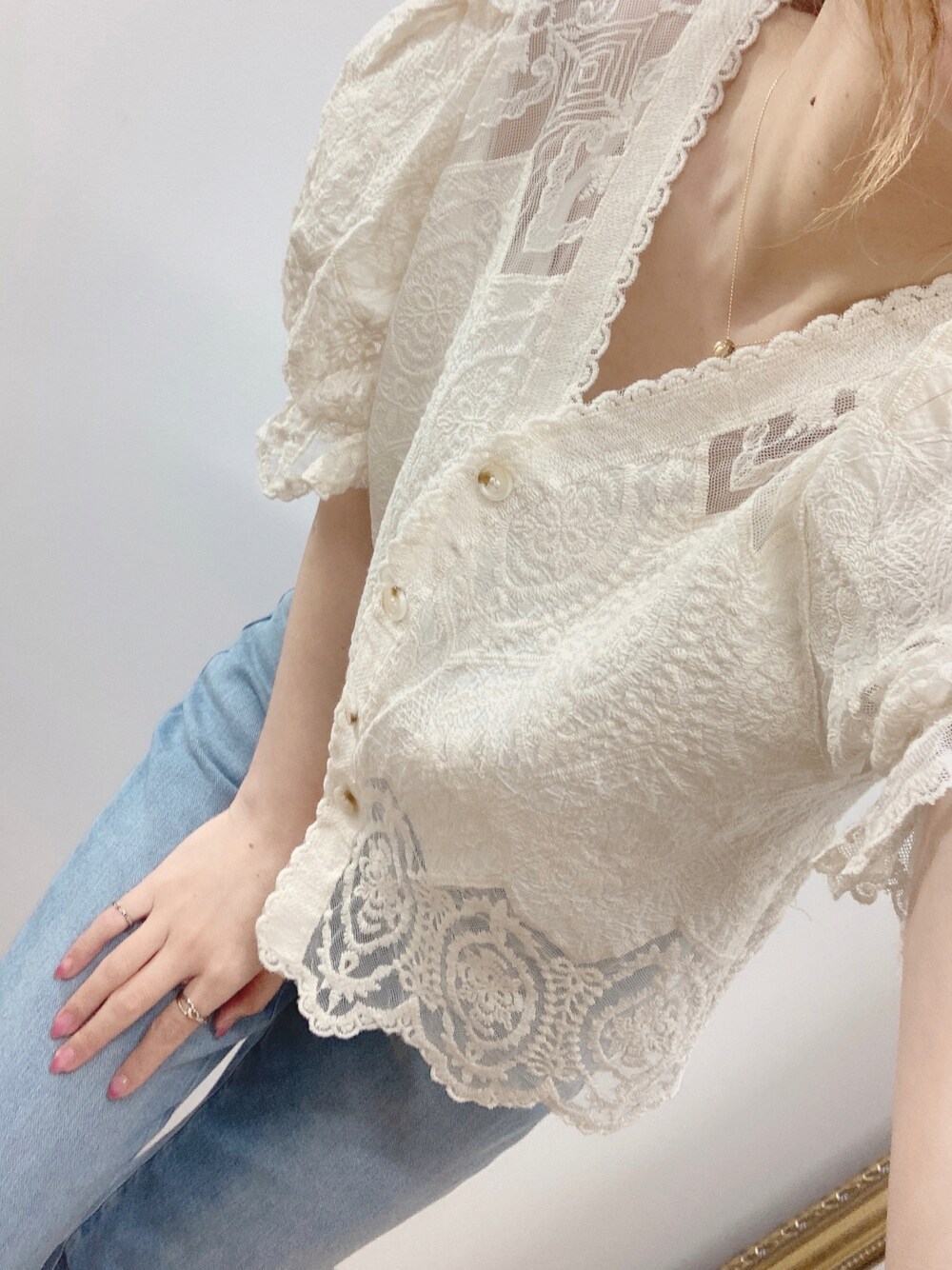 ホワイト系のカーディガン/ボレロ、ブルー系のデニムパンツを着用したレディースの春コーディネートの1枚目の写真