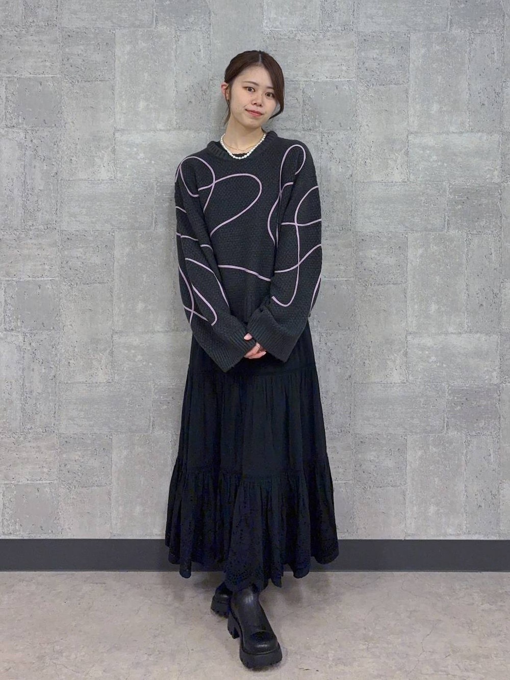 ブラック系のブーツ、グレー系のニット/セーター、ブラック系のスカートを着用したレディースの秋コーディネートの1枚目の写真