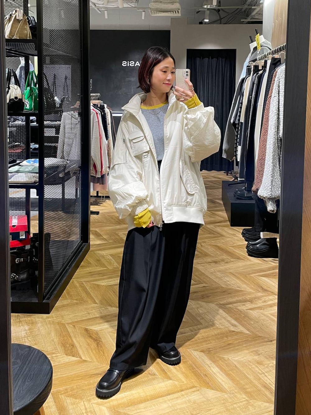 ホワイト系のブルゾン、ブラック系のローファー、ブラック系のスラックスを着用したレディースの秋コーディネートの1枚目の写真