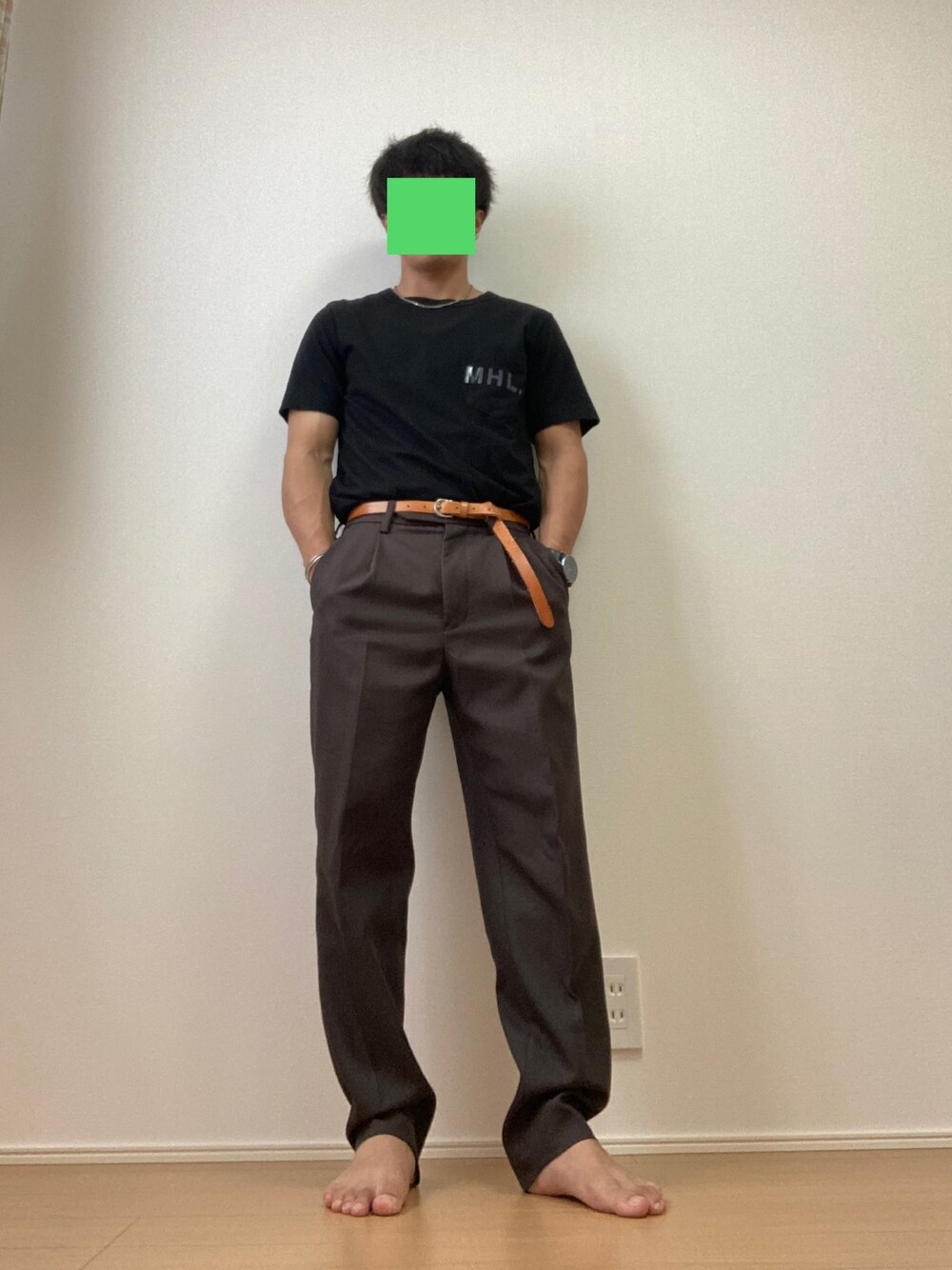 ホワイト系のTシャツ/カットソー、ブラウン系のスラックス、ブラック系のサンダルを着用したメンズの夏コーディネートの1枚目の写真