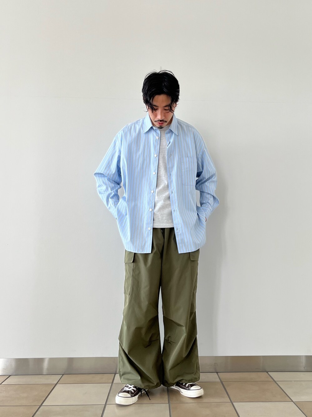 グリーン系のカーゴパンツ、ブルー系のシャツ/ブラウスを着用したメンズの春コーディネートの1枚目の写真