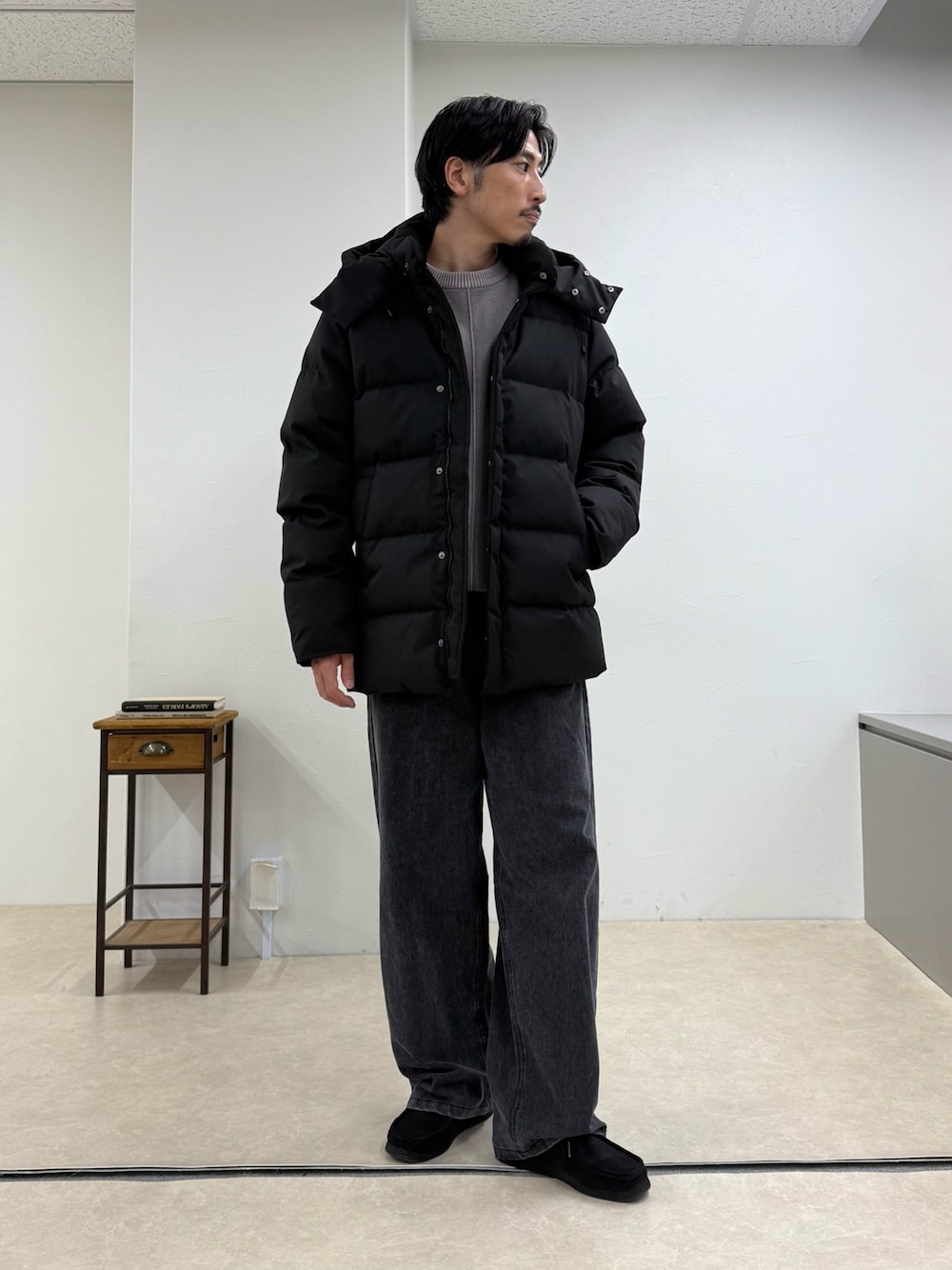 ブラック系のダウンジャケット/コート、ベージュ系のニット/セーター、グレー系のその他パンツを着用したメンズの秋コーディネートの1枚目の写真