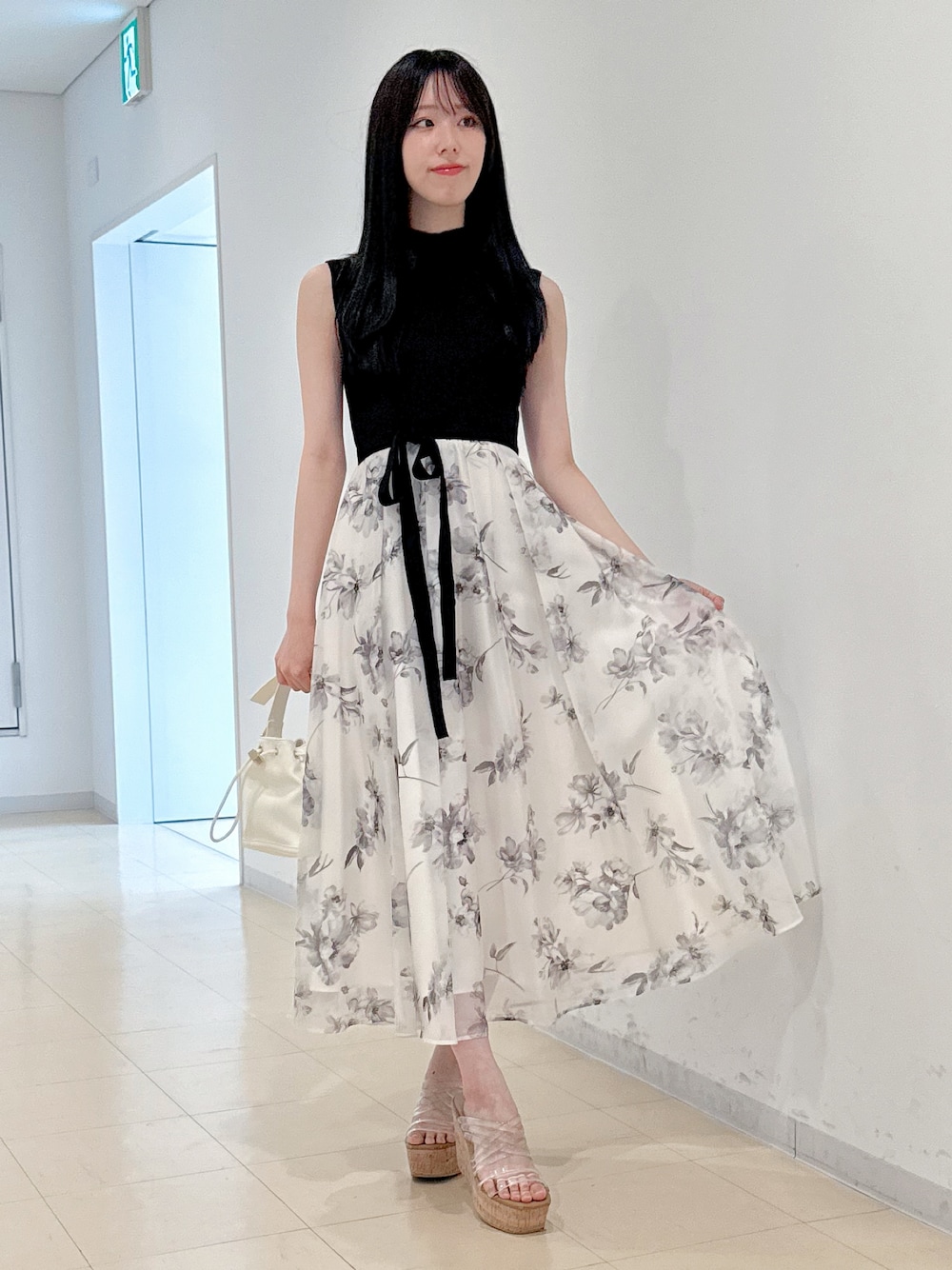 ホワイト系のワンピース、ホワイト系のハンドバッグ、その他のサンダルを着用したレディースの春コーディネートの1枚目の写真