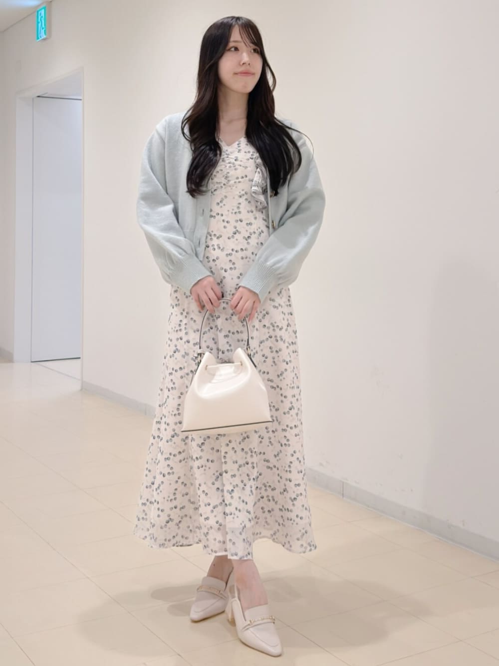 ホワイト系のショルダーバッグ、グリーン系のカーディガン/ボレロ、ホワイト系のワンピースを着用したレディースの冬コーディネートの1枚目の写真