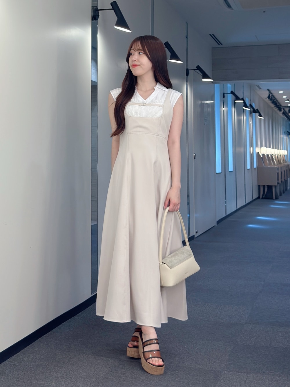 ピンク系のワンピース、ホワイト系のハンドバッグ、ブラウン系のサンダルを着用したレディースの夏コーディネートの1枚目の写真