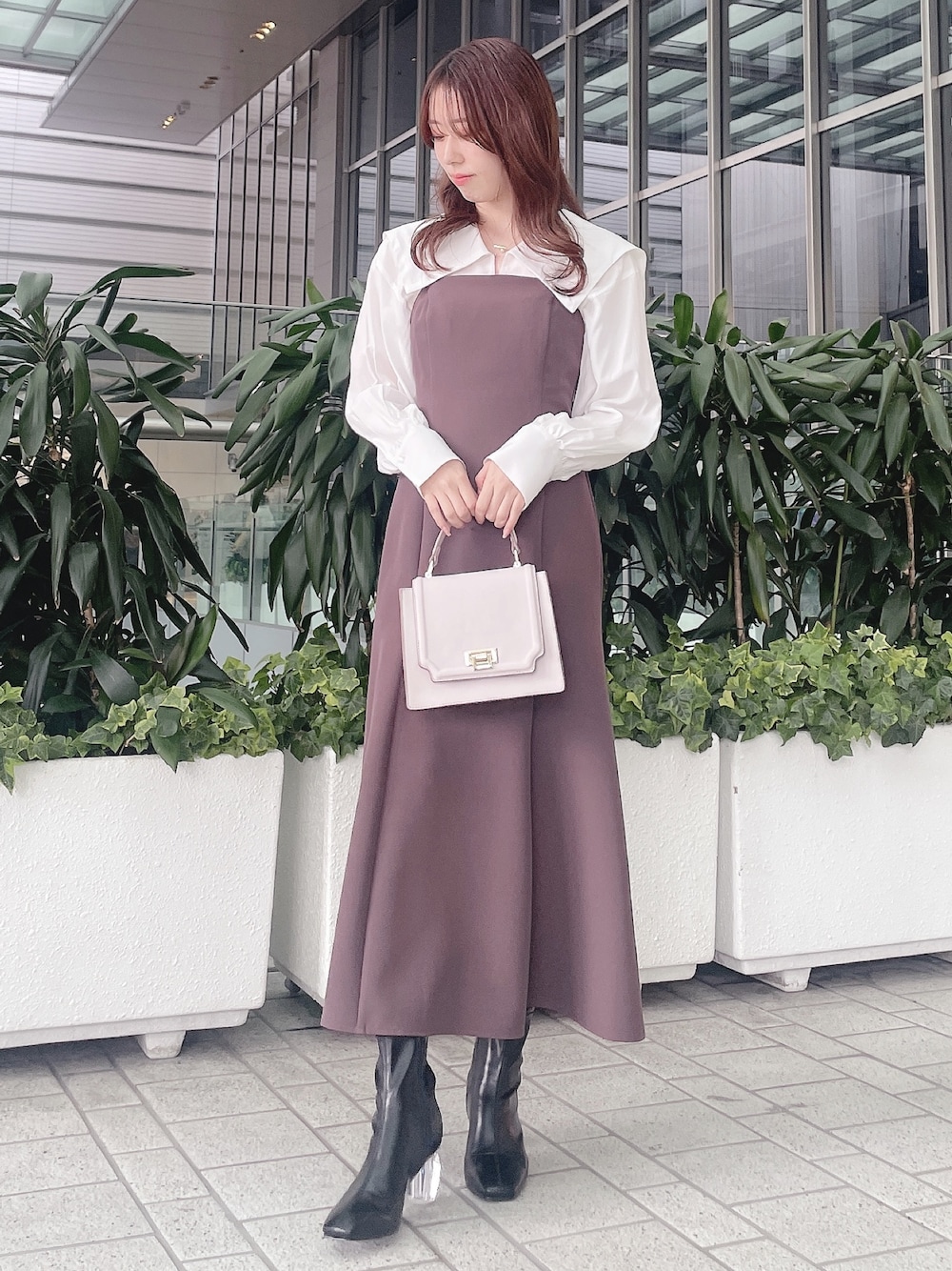 パープル系のワンピース、ブラック系のブーツを着用したレディースの冬コーディネートの1枚目の写真