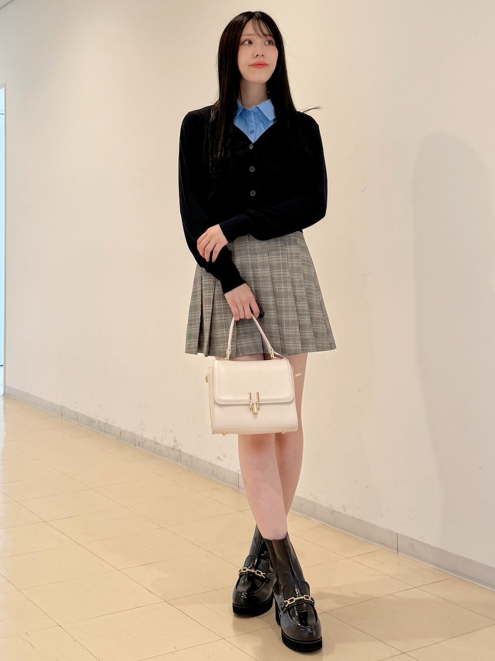 ブルー系のシャツ/ブラウス、グレー系のスカート、ホワイト系のハンドバッグを着用したレディースの夏コーディネートの1枚目の写真