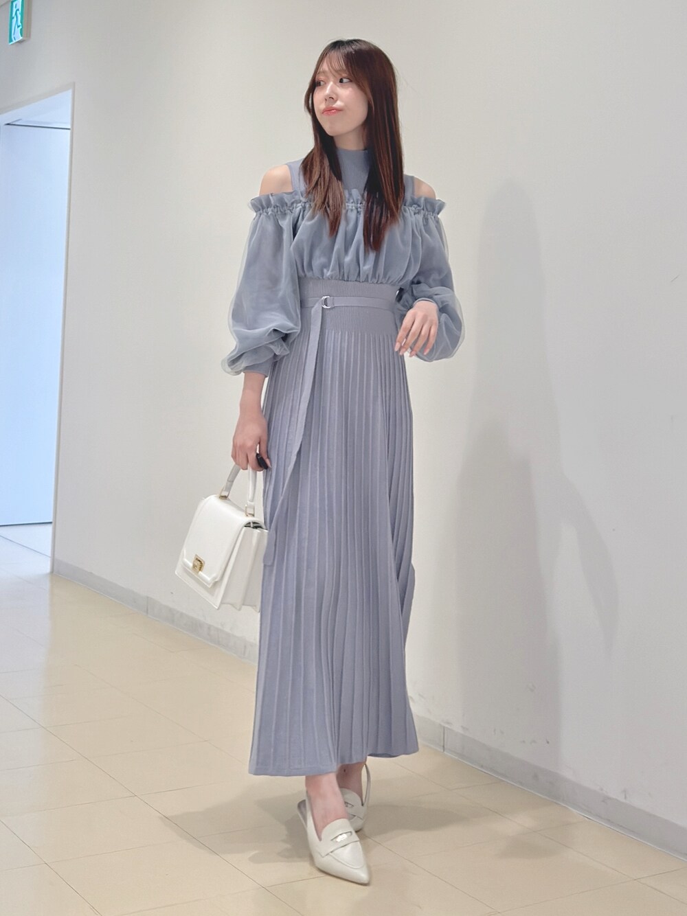 ブルー系のワンピース、ホワイト系のハンドバッグ、ホワイト系のパンプスを着用したレディースの冬コーディネートの1枚目の写真