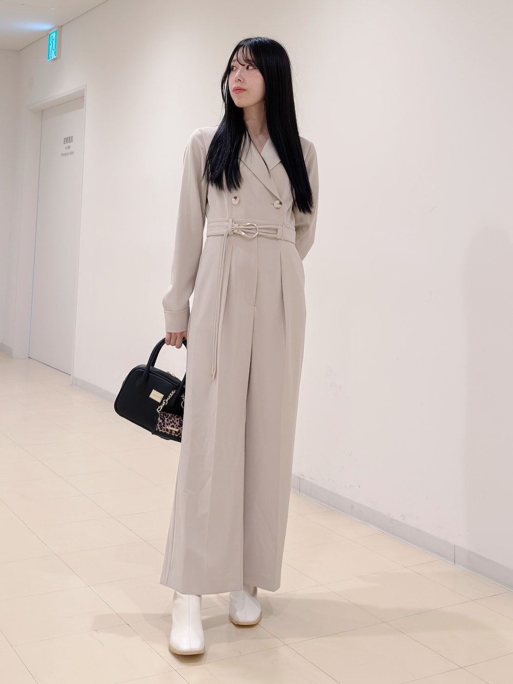 ベージュ系のつなぎ/オールインワン、ブラック系のハンドバッグ、ホワイト系のブーツを着用したレディースの秋コーディネートの1枚目の写真