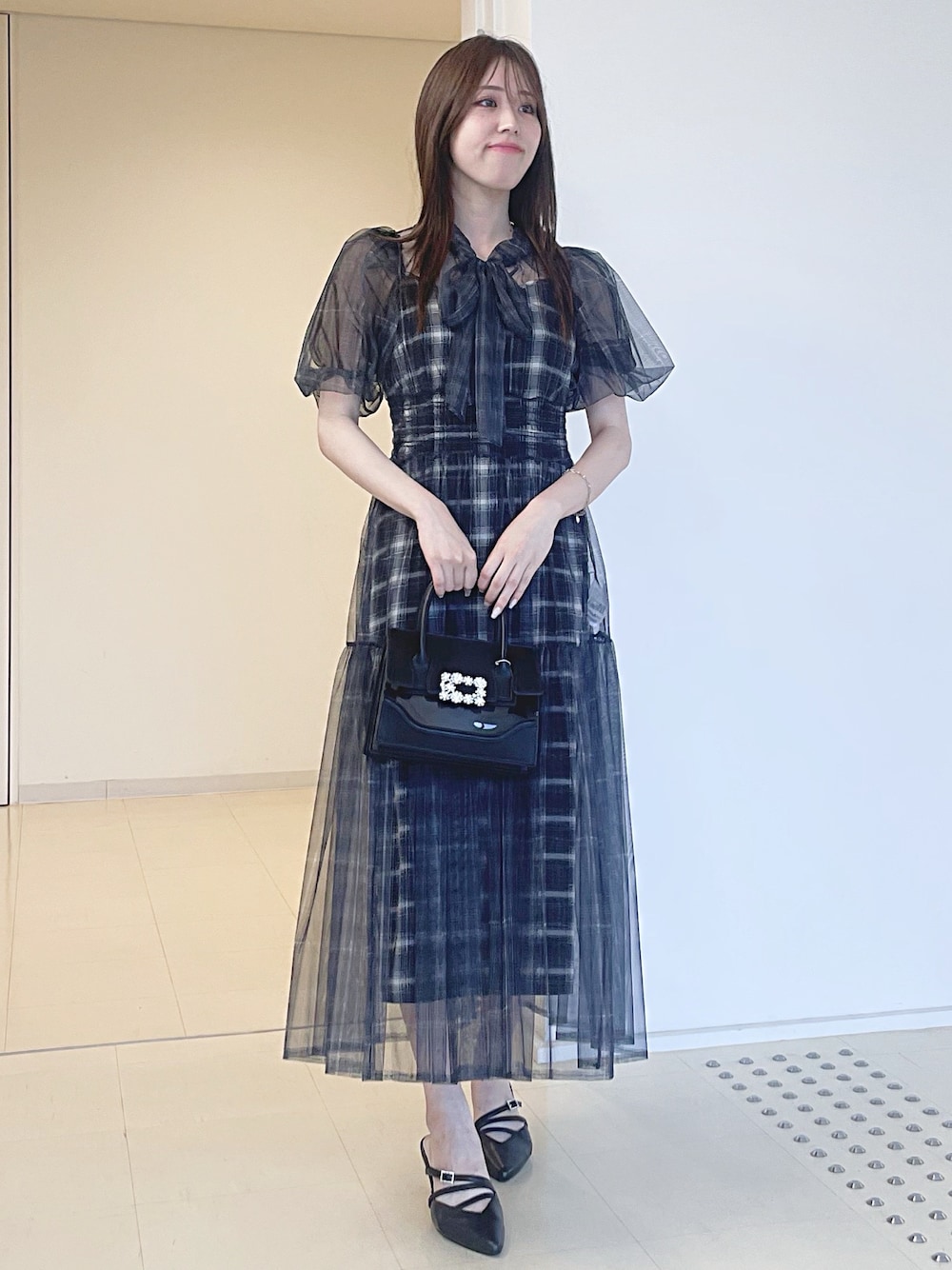 ブラック系のワンピース、ブラック系のショルダーバッグ、ブラック系のパンプスを着用したレディースの夏コーディネートの1枚目の写真