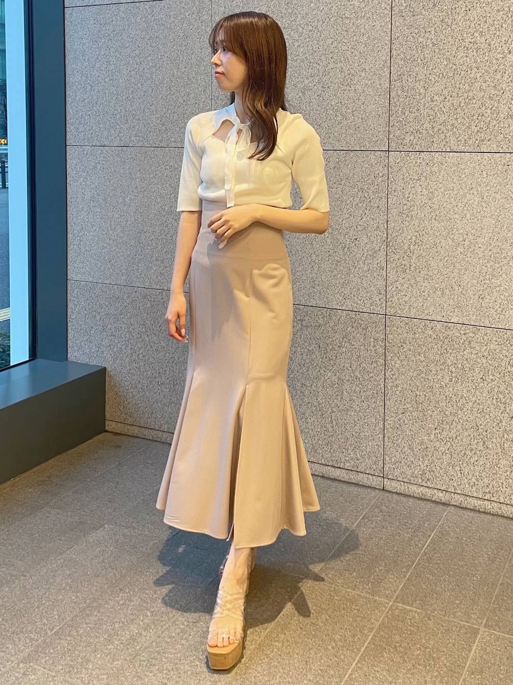 ピンク系のスカート、ホワイト系のサンダル、ホワイト系のニット/セーターを着用したレディースの春コーディネートの1枚目の写真