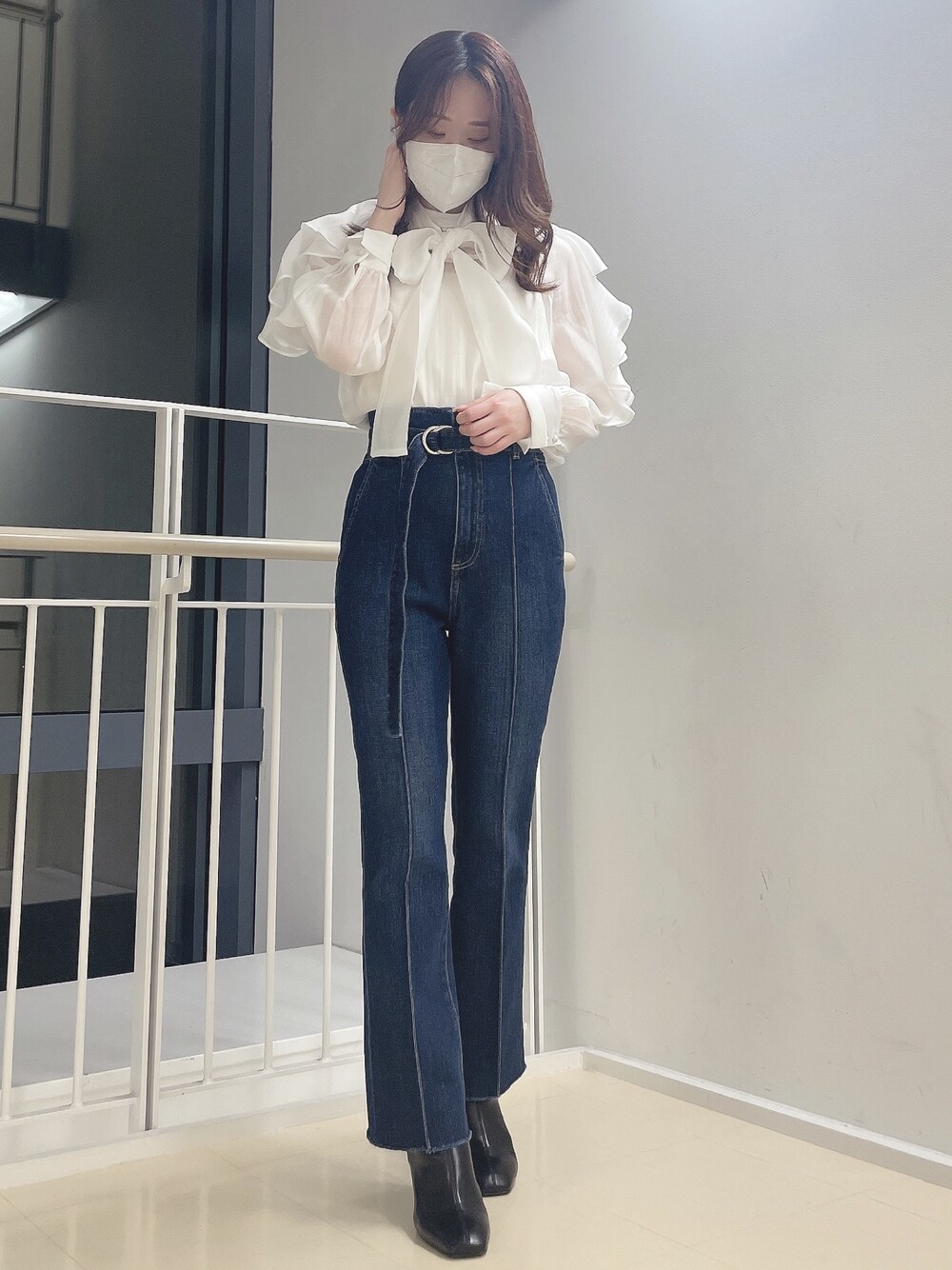 ブルー系のデニムパンツ、ホワイト系のシャツ/ブラウス、ブラック系のブーツを着用したレディースの冬コーディネートの1枚目の写真