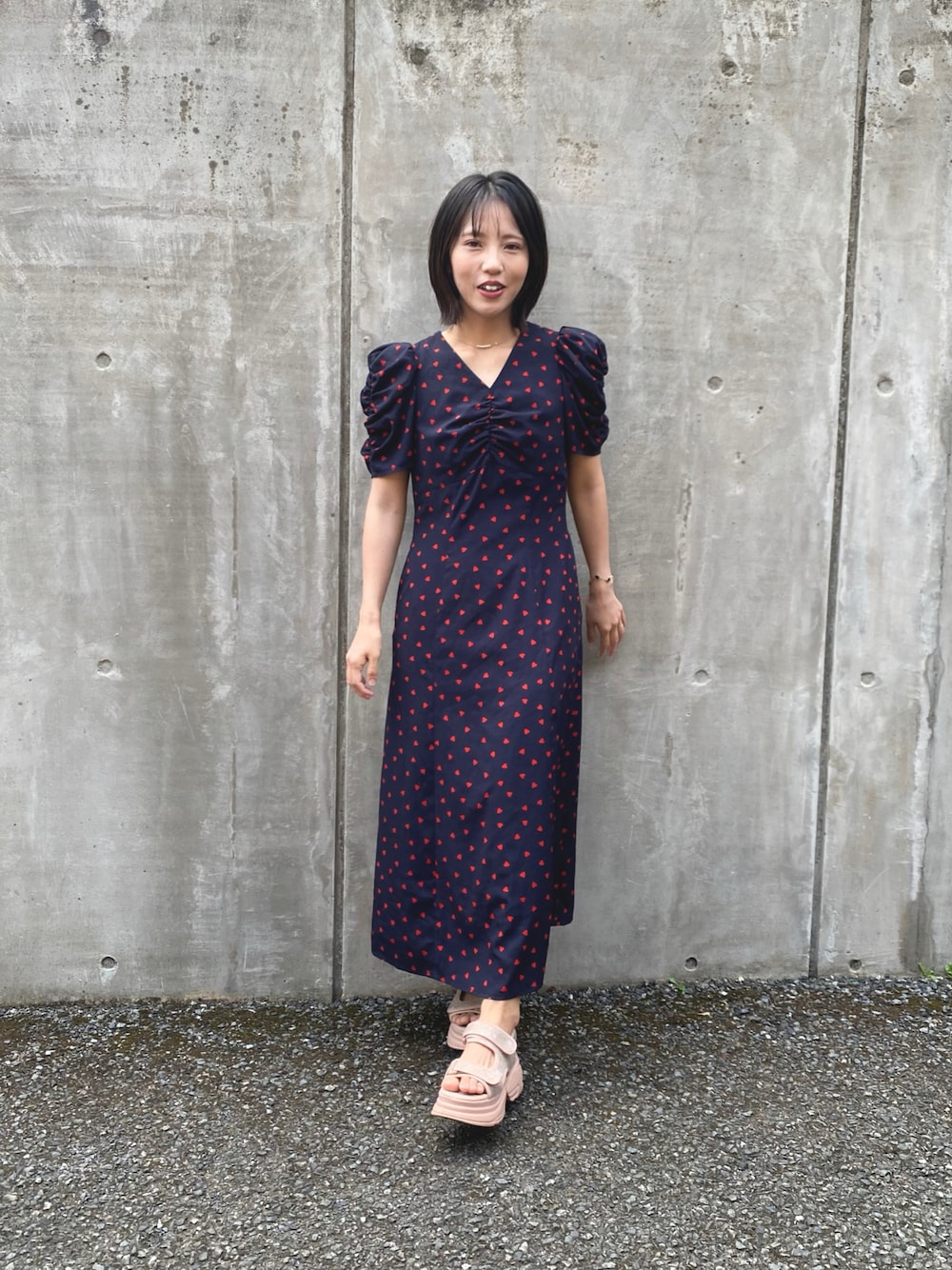 ブルー系のワンピース、ピンク系のサンダルを着用したレディースの夏コーディネートの1枚目の写真