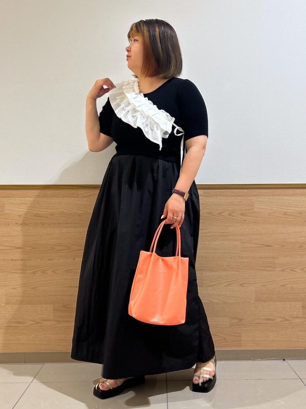 ゴールド系のサンダル、ピンク系のトートバッグ、ブラック系のワンピースを着用したレディースの夏コーディネートの1枚目の写真