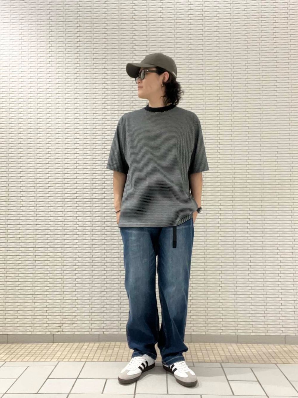 ブラック系のTシャツ/カットソー、ブルー系のデニムパンツ、ホワイト系のスニーカーを着用したメンズの夏コーディネートの1枚目の写真