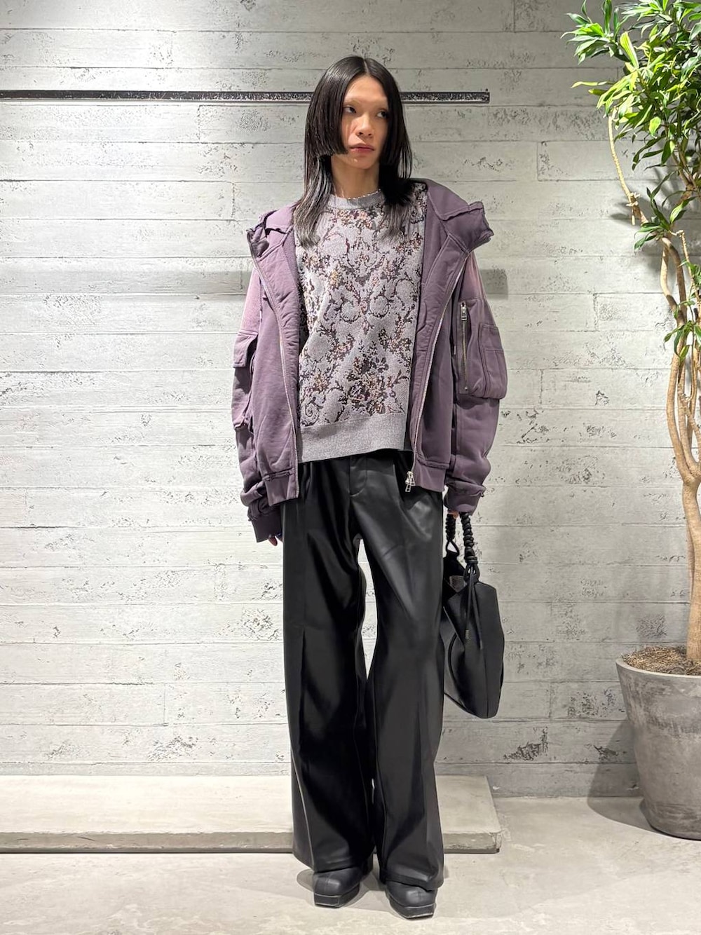 グレー系のニット/セーター、ブラック系のスラックス、パープル系のパーカーを着用したメンズの秋コーディネートの1枚目の写真