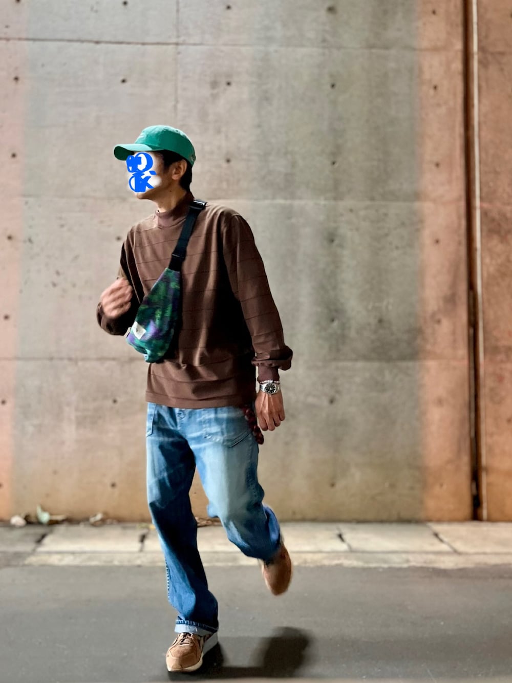 ブラウン系のTシャツ/カットソー、ブルー系のデニムパンツ、グリーン系のボディバッグ/ウエストポーチを着用したメンズの秋コーディネートの1枚目の写真