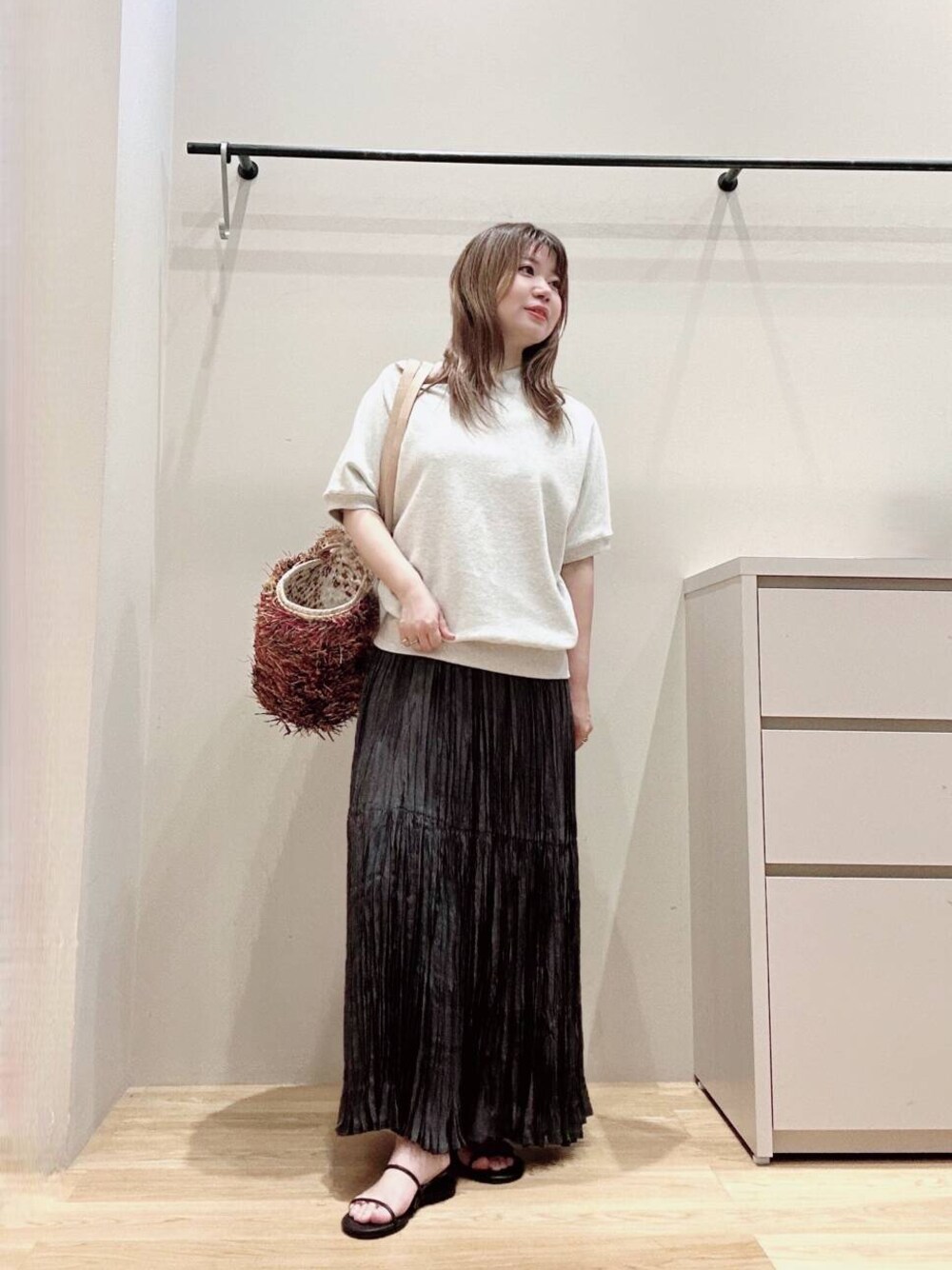 グレー系のスカート、ブラック系のサンダル、グレー系のTシャツ/カットソーを着用したレディースの春コーディネートの1枚目の写真