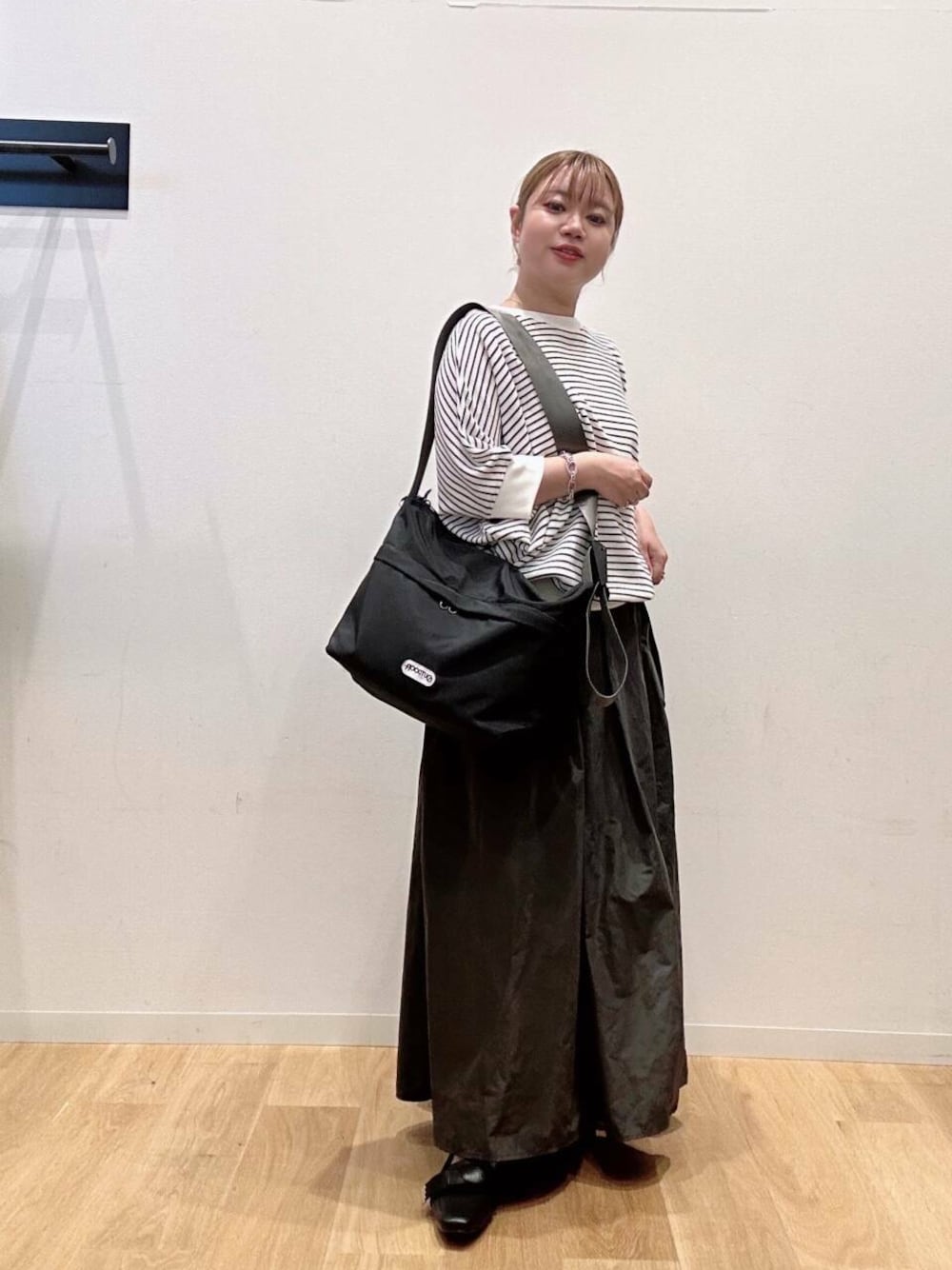 ホワイト系のTシャツ/カットソー、ブラック系のドレスシューズ、ブラック系のショルダーバッグを着用したレディースの夏コーディネートの1枚目の写真