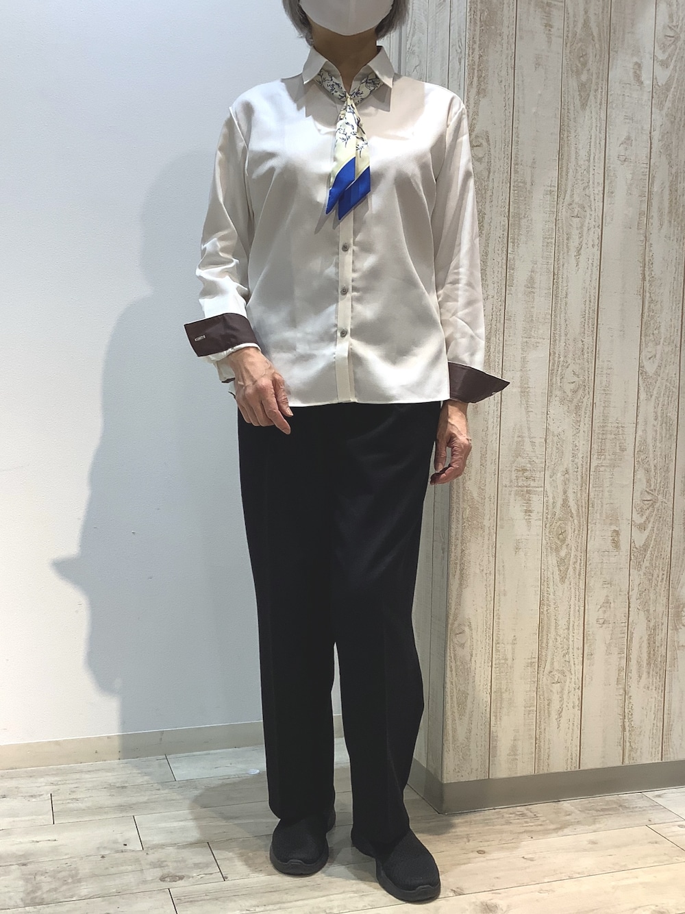 イエロー系のビジネスシャツを着用したレディースの冬コーディネートの1枚目の写真