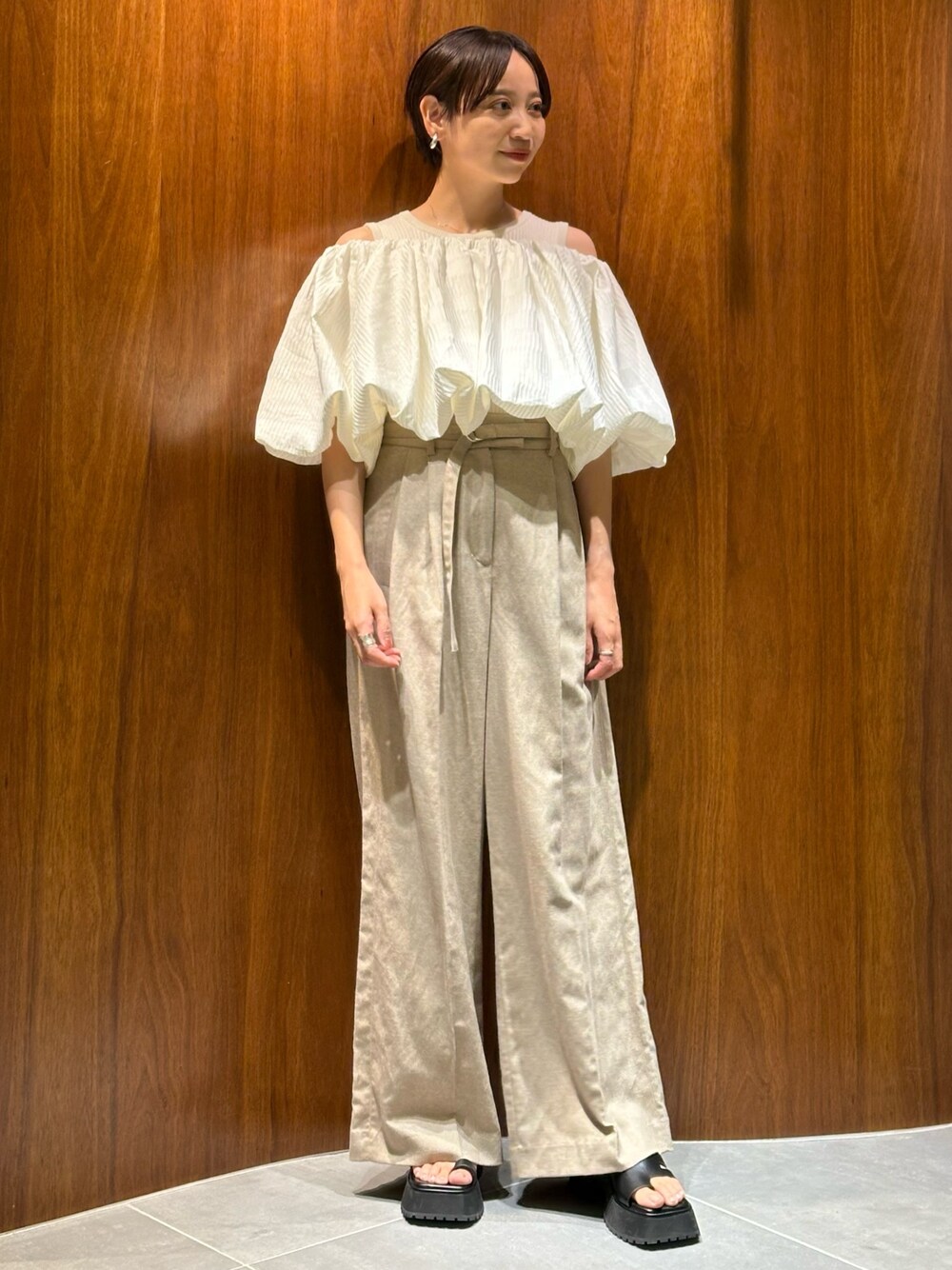 ホワイト系のシャツ/ブラウス、ベージュ系のその他パンツ、ブラック系のサンダルを着用したレディースの夏コーディネートの1枚目の写真