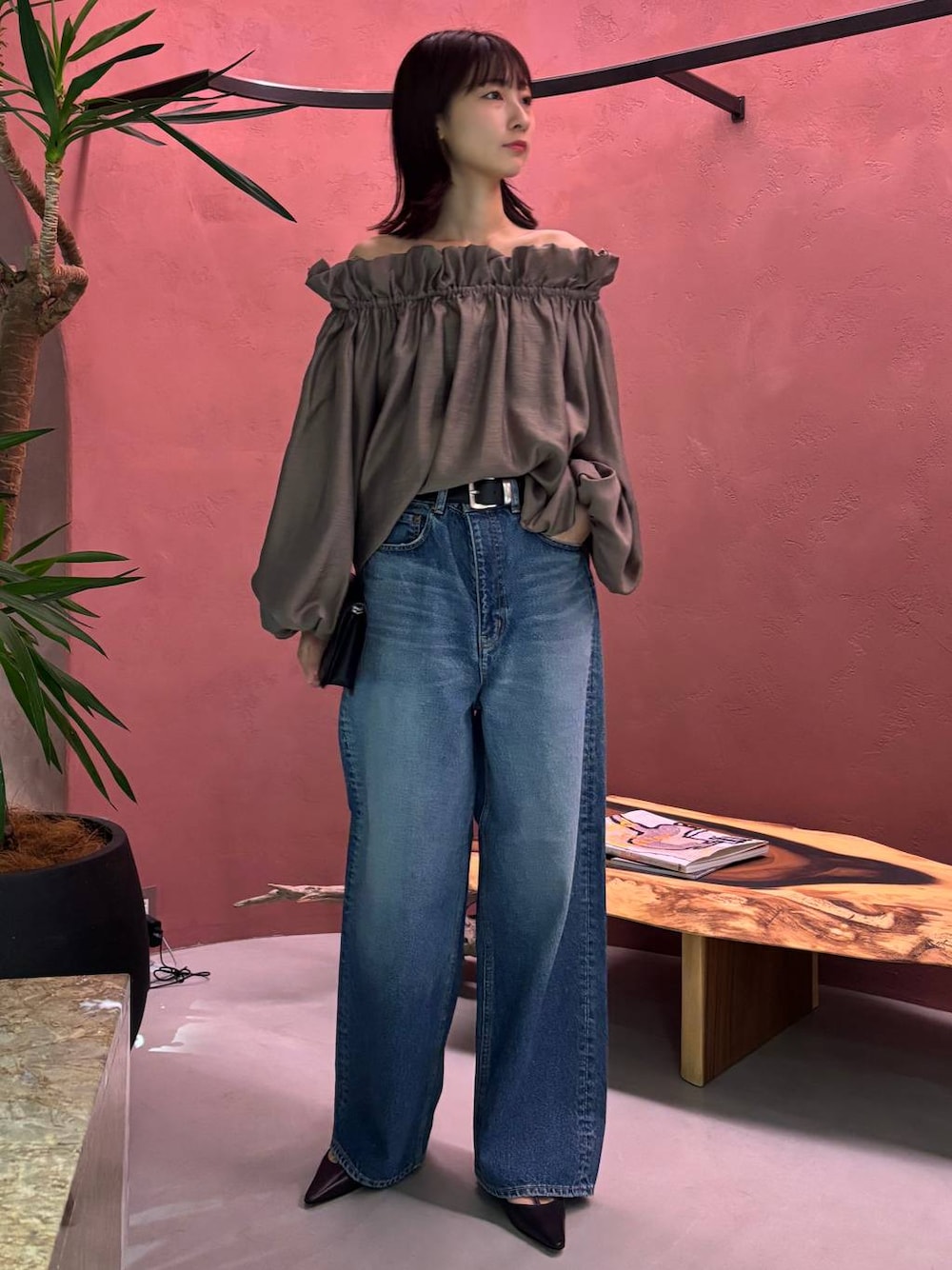 ブルー系のデニムパンツ、ブラック系のベルトを着用したレディースの秋コーディネートの1枚目の写真