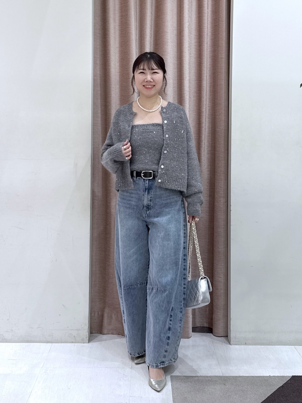 グレー系のカーディガン/ボレロ、グレー系のチューブトップ、ブルー系のデニムパンツを着用したレディースの秋コーディネートの1枚目の写真